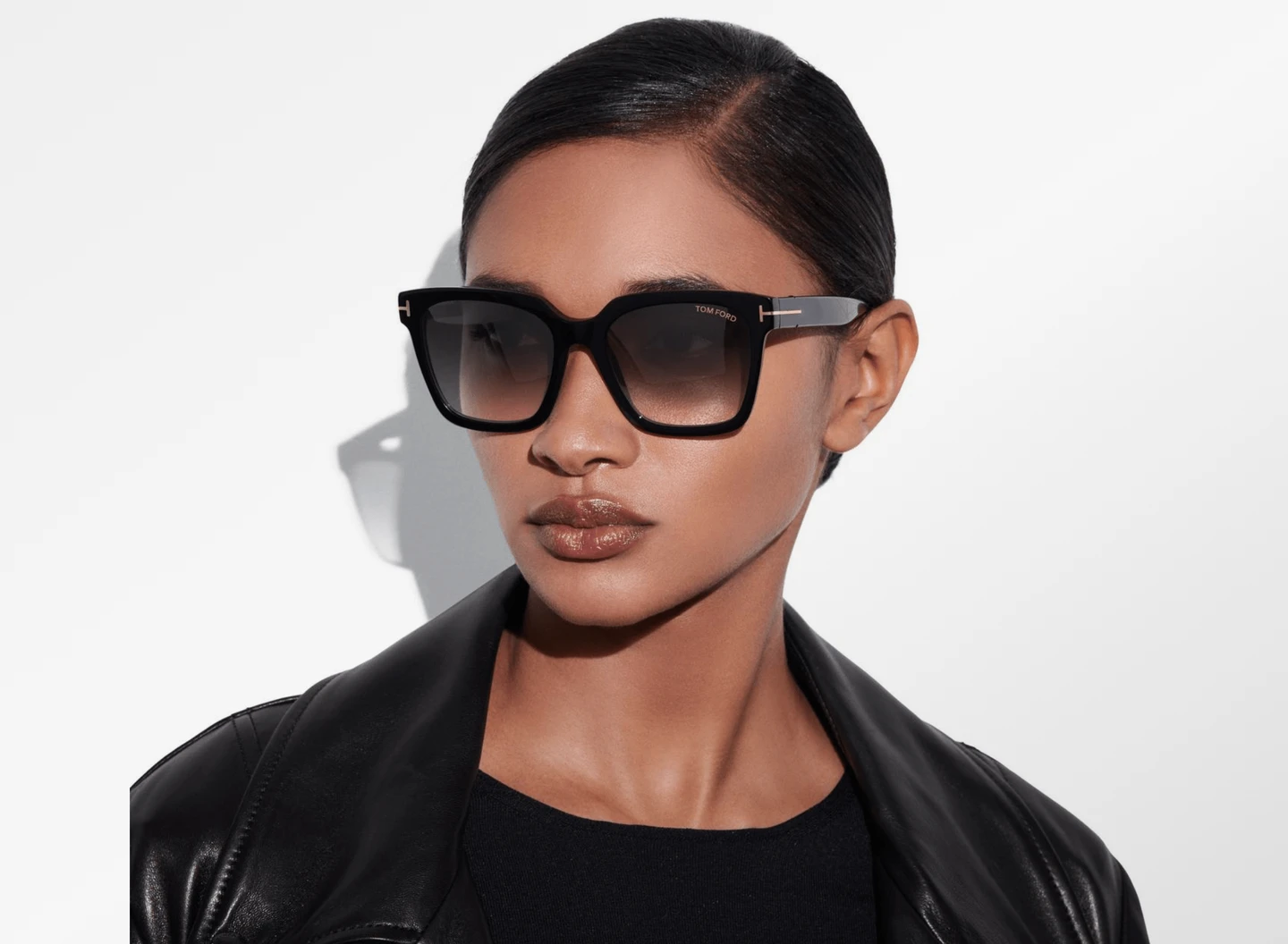 Frau mit einer Tom Ford Selby Sonnenbrille für Damen in Schwarz mit eckiger Fassung und T-Logo im Gesicht
