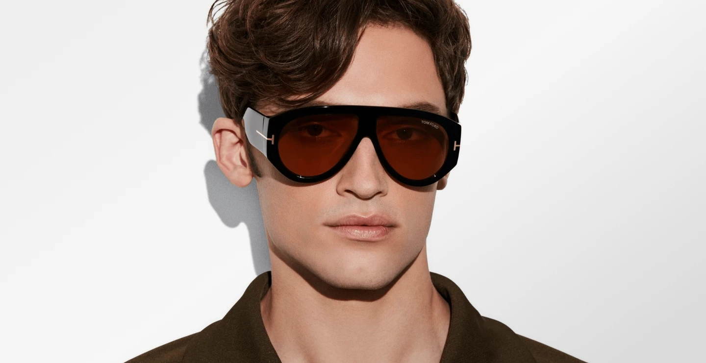 Mann trägt Tom Ford Herren-Sonnenbrille im Piloten-Stil aus schwarzem Acetat mit braunen Gläsern und T-Logo und breitem Steg
